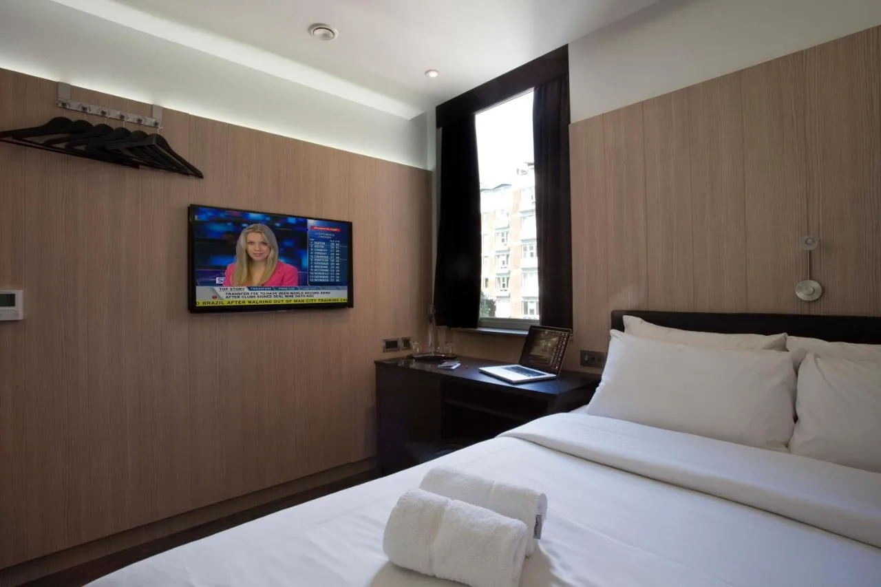 a bedroom with a bed and a tv on the wall at The Z Hotel Victoria in London